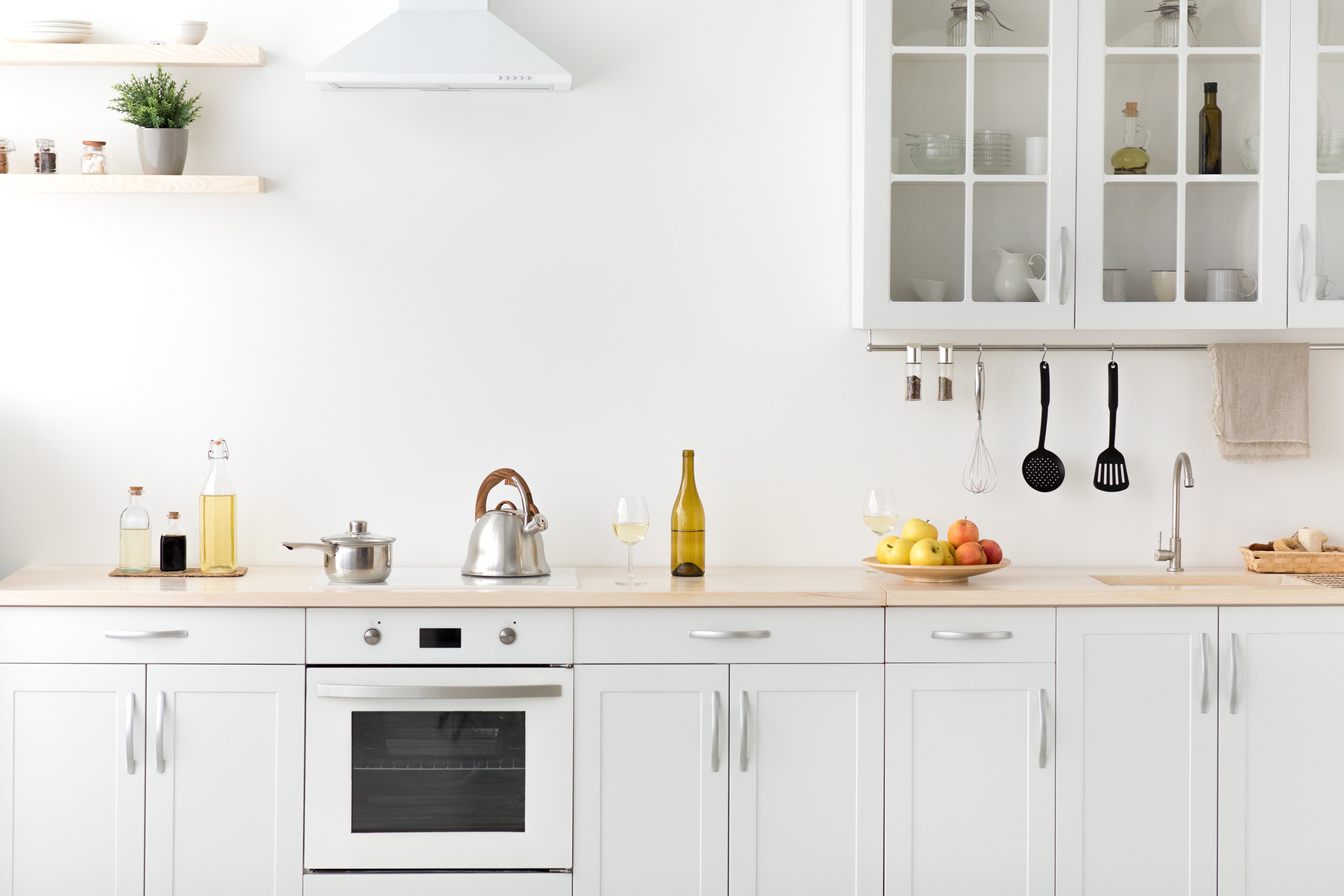 A clean, bright kitchen with white cabinets and a white wall