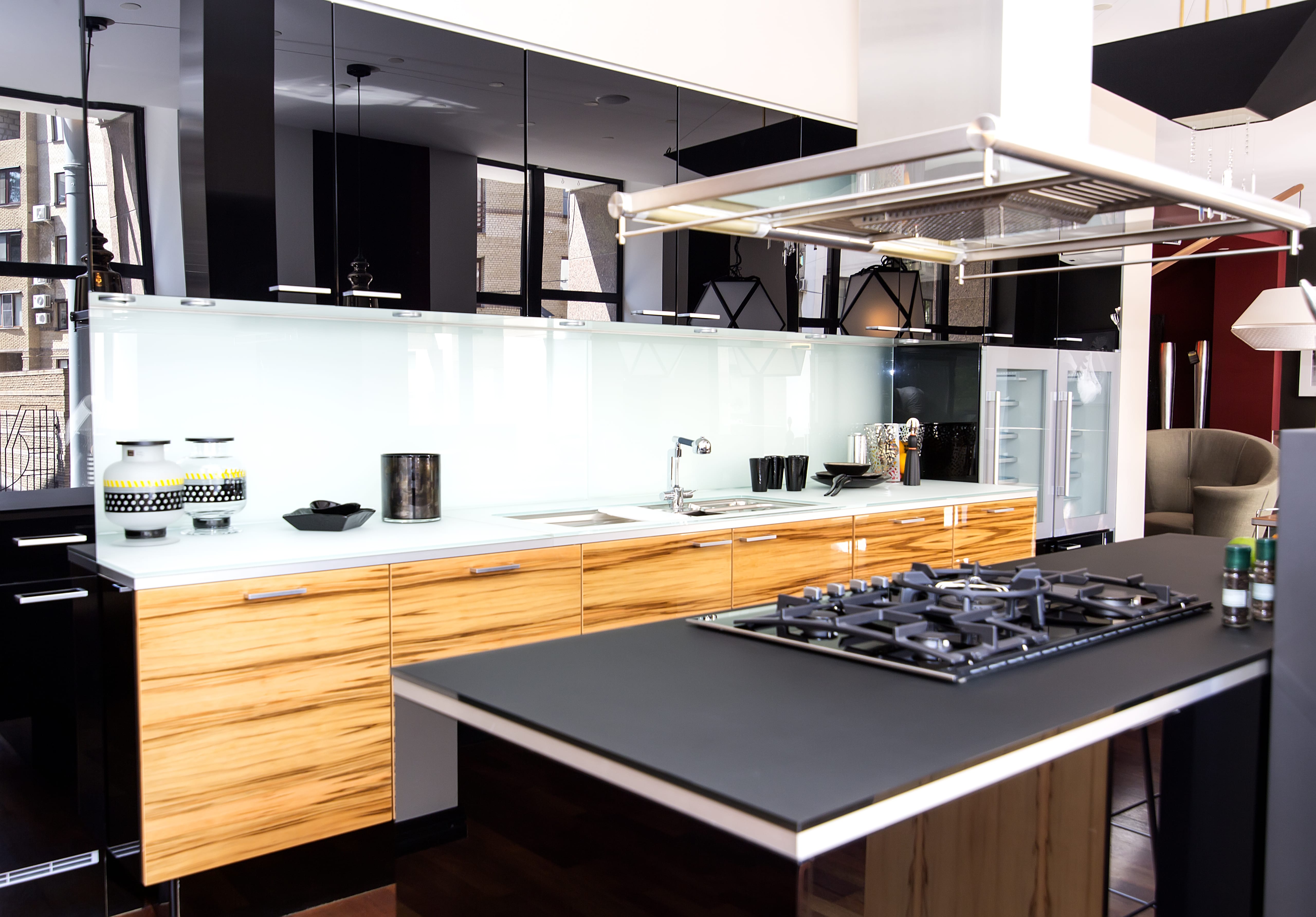 A clean, sleek kitchen with high gloss black cabinets reflecting the natural light outside
